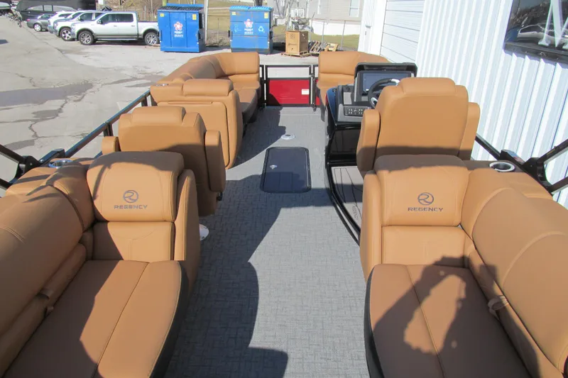 Slide: The Image of 2026 Regency 230 DL pontoon boat interior with tan seating and modern dashboard. - 6