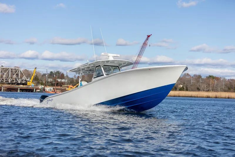Slide: The Image of 2018 Yellowfin 39 Offshore boat cruising on a sunny day, blue and white design. - 19