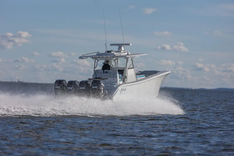 Slide: The Image of 2018 Yellowfin 39 Offshore boat speeding on open water under a clear sky. - 23