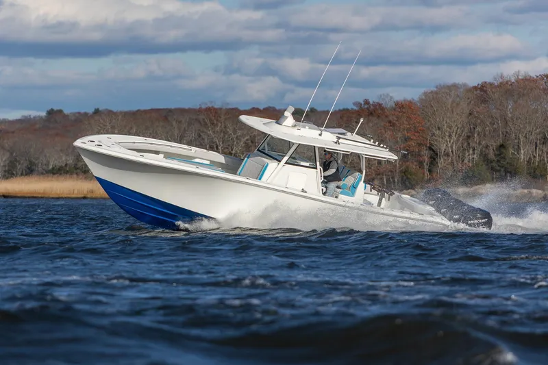 Slide: The Image of 2018 Yellowfin 39 Offshore boat cruising on a lake with scenic background. - 38