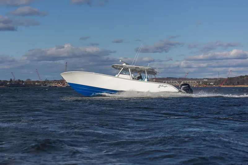Slide: The Image of 2018 Yellowfin 39 Offshore boat cruising on open water under a partly cloudy sky. - 40