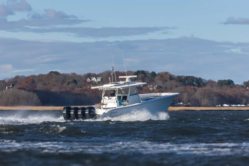 Slide: The Image of 2018 Yellowfin 39 Offshore boat cruising on a scenic waterway with wooded shoreline. - 42