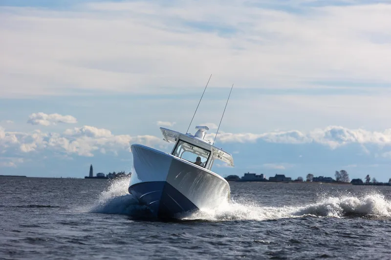 Slide: The Image of 2018 Yellowfin 39 Offshore boat navigating choppy waters under a cloudy sky. - 56