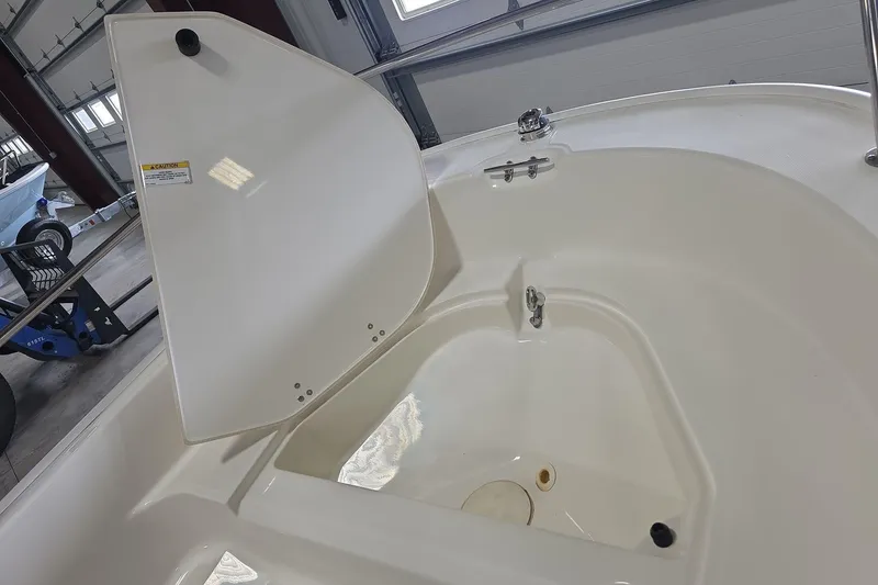 Slide: The Image of 2020 Boston Whaler 110 Sport boat interior, showcasing storage compartment and sleek design. - 10