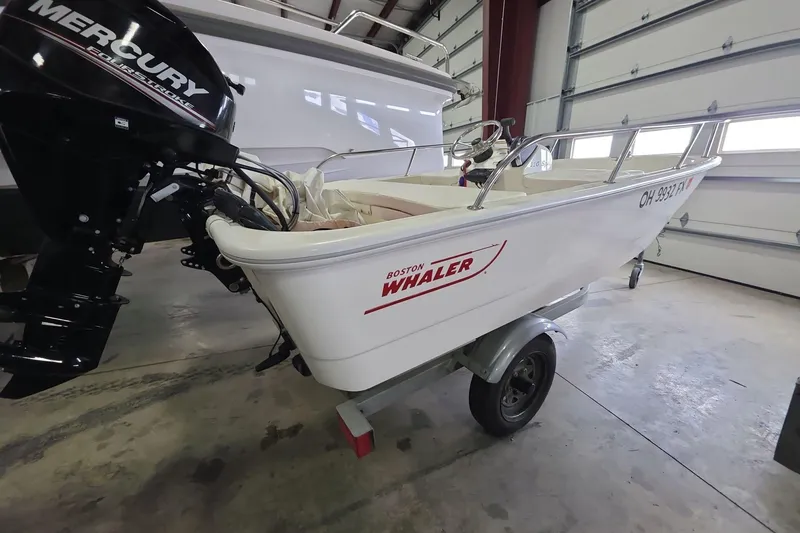 Slide: The Image of 2020 Boston Whaler 110 Sport boat with Mercury engine in a garage setting. - 3