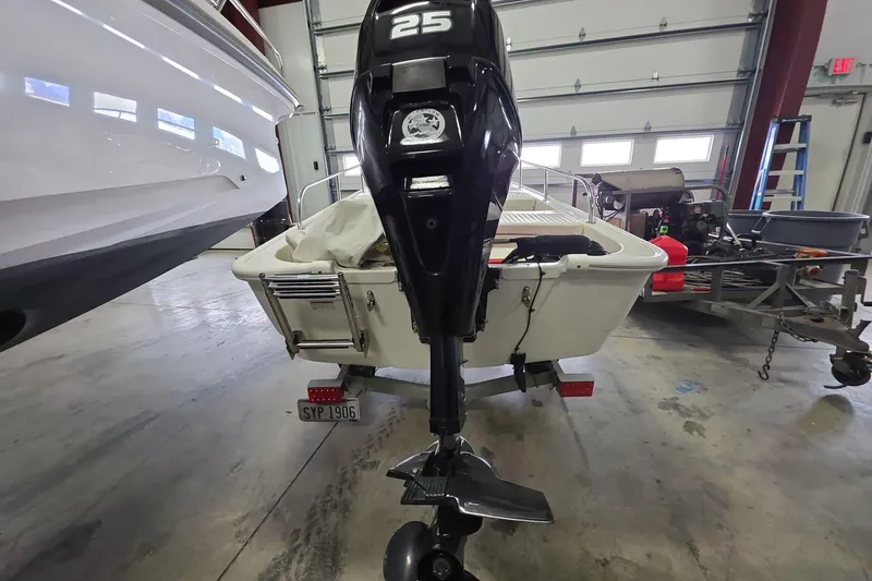 Slide: The Image of 2020 Boston Whaler 110 Sport with 25 HP outboard motor in a garage setting. - 4