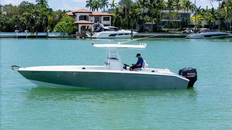 Slide: The Image of A 1999 Monza 31 boat on turquoise water with palm trees in the background. - 1