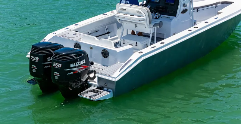 Slide: The Image of 1999 Monza 31 boat with dual Suzuki 250 outboard engines on green water. - 13