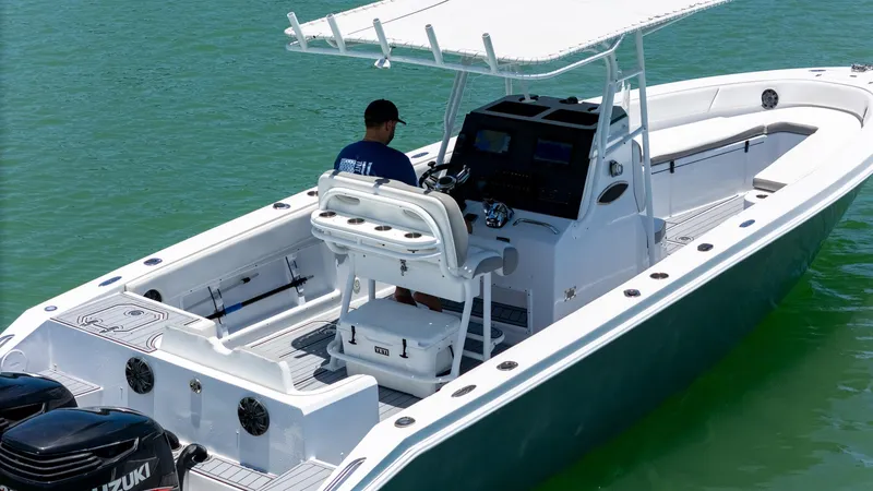 Slide: The Image of 1999 Monza 31 boat on water, featuring a center console and dual Suzuki engines. - 14