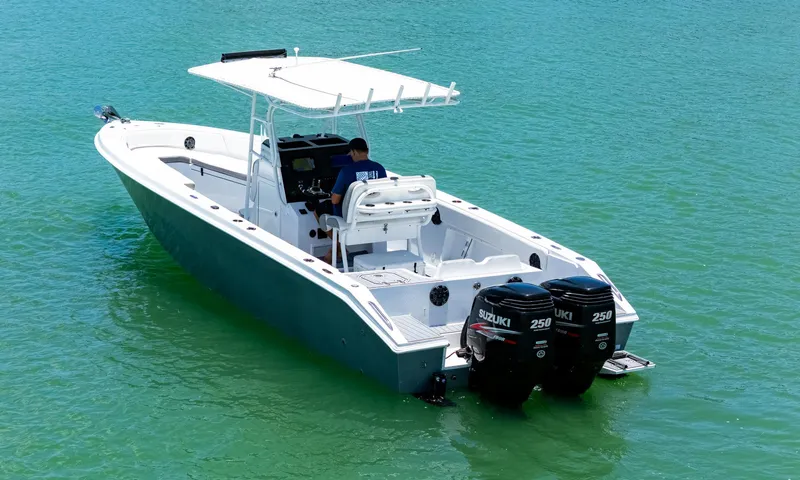 Slide: The Image of A 1999 Monza 31 boat on calm water near luxury waterfront homes. - 2