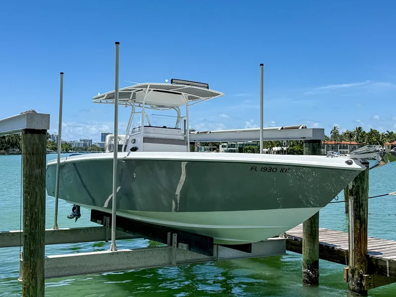 Slide: The Image of Boat on lift, Monza 31, 1999 model, docked by turquoise water under clear blue sky. - 23