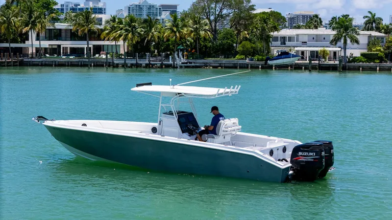 Slide: The Image of Boat on turquoise water, Monza 31 model, 1999, with dual Suzuki engines, near waterfront homes. - 4