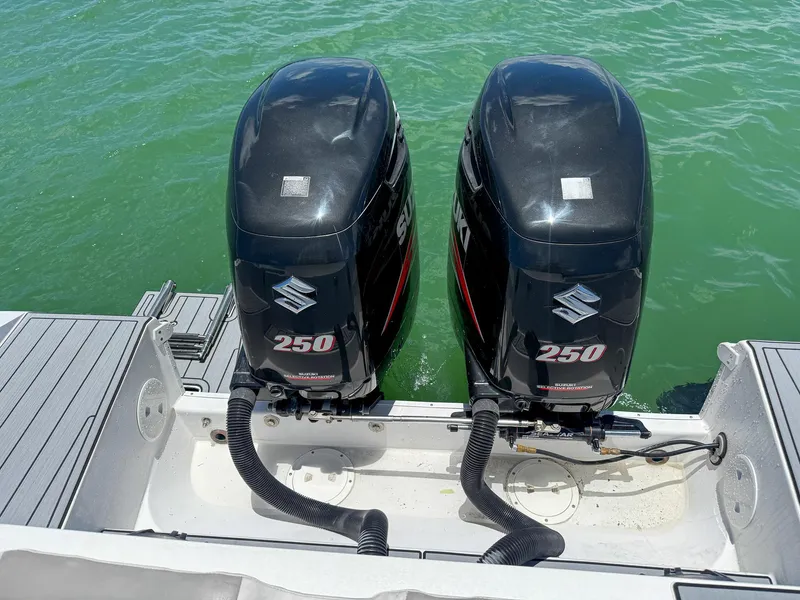 Slide: The Image of Twin Suzuki 250 outboard motors on a Monza 31 boat, 1999 model, in green water. - 40