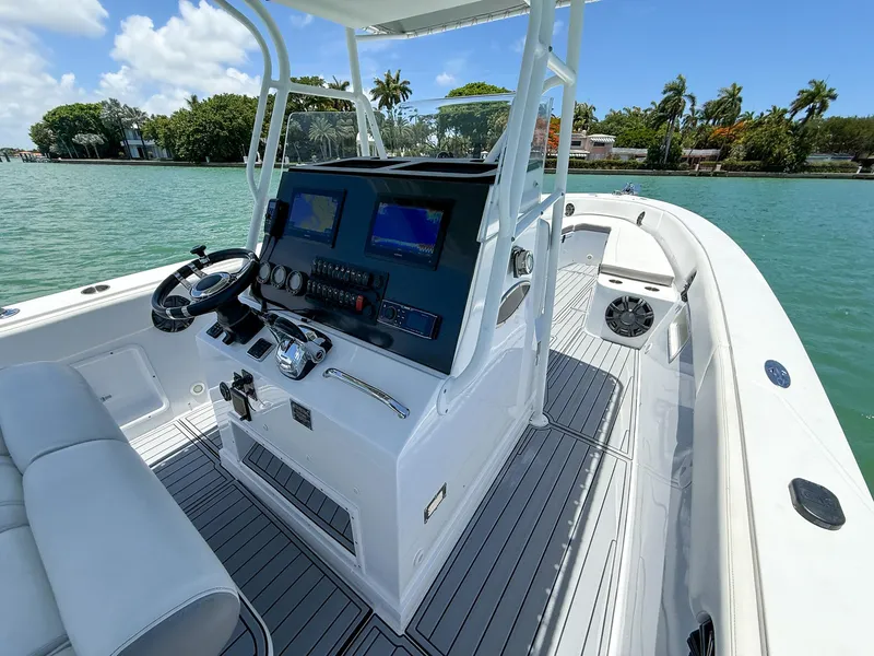 Slide: The Image of 1999 Monza 31 boat interior with steering wheel, control panel, and seating on a sunny day. - 44