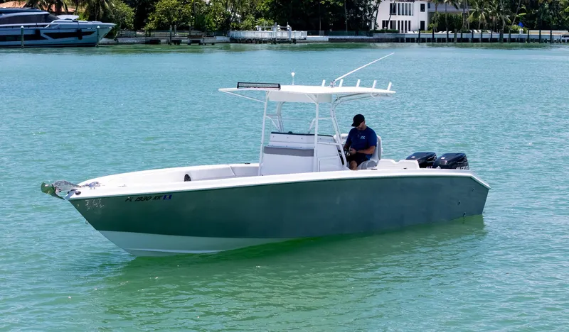 Slide: The Image of Boat on turquoise water, Monza 31 model, 1999, with palm trees and buildings in the background. - 5