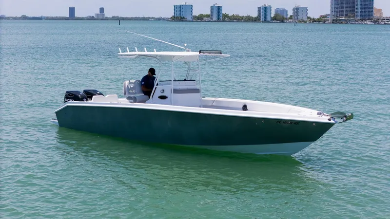 Slide: The Image of A 1999 Monza 31 boat floating on calm, clear water with a city skyline in the background. - 9