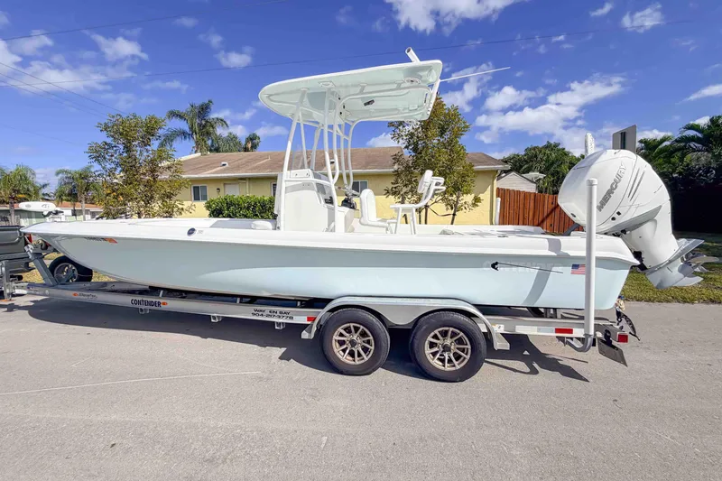 The Image of 2023 Contender 26 Bay boat on trailer, parked outdoors under a clear blue sky. - 0