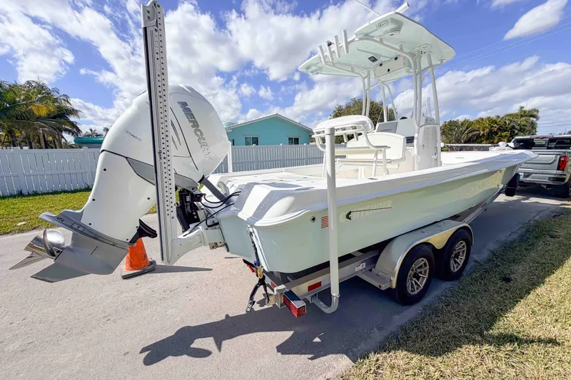 Slide: The Image of 2023 Contender 26 Bay boat with Mercury engine on trailer, parked outdoors. - 3