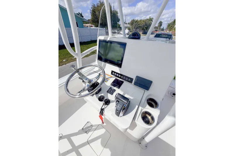 Slide: The Image of 2023 Contender 26 Bay boat console with steering wheel and navigation display. - 7