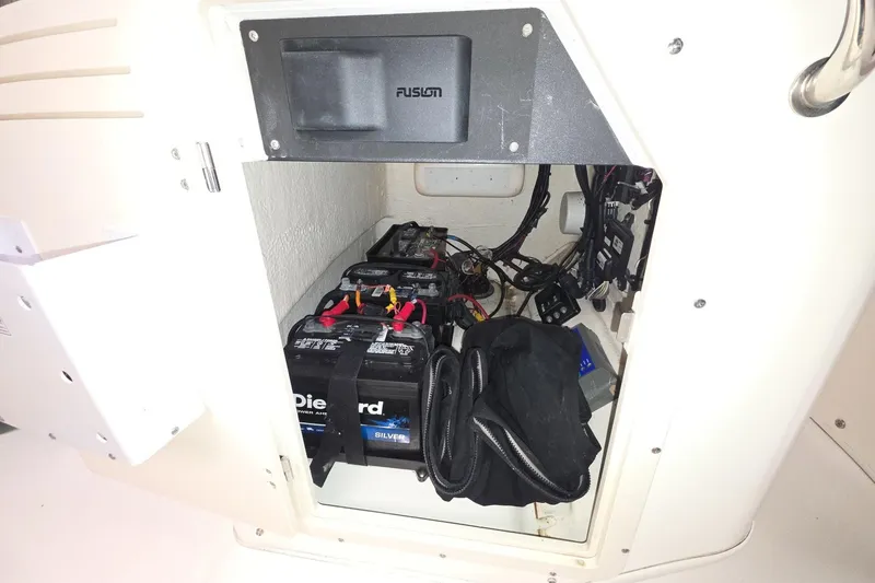 Slide: The Image of 2011 Boston Whaler 190 Montauk battery compartment with DieHard batteries and wiring. - 10