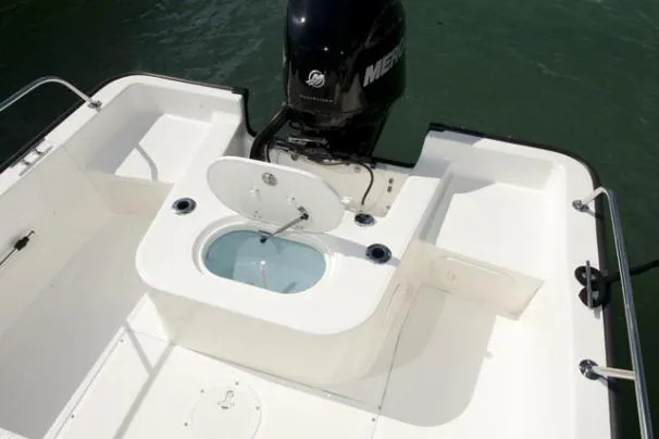 Slide: The Image of 2011 Boston Whaler 190 Montauk with Mercury outboard engine in a garage setting. - 5