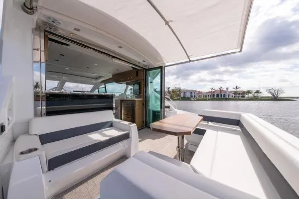 Slide: The Image of 2018 Cruisers Yachts 50 Cantius luxury deck with seating, table, and waterfront view. - 9