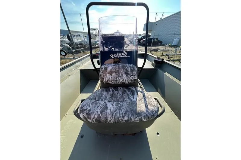Slide: The Image of 2021 Tracker Grizzly 2072 CC boat with camo seats and console, parked outdoors. - 7