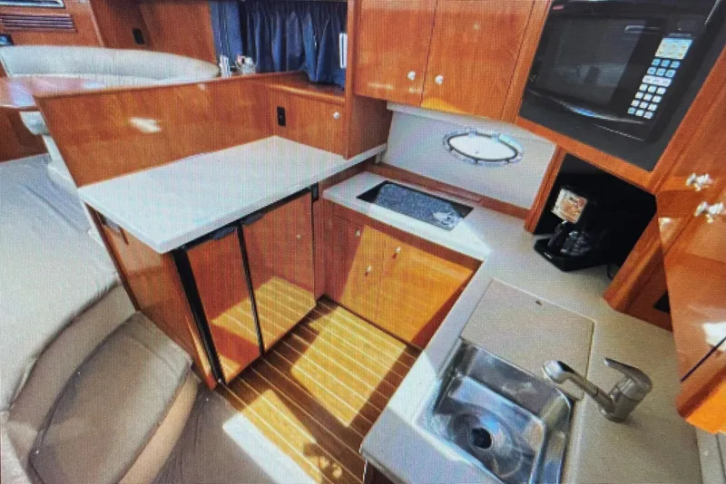 Slide: The Image of Luxurious 2006 Cruisers Yachts 385 Motoryacht kitchen with modern amenities and wood finish. - 17