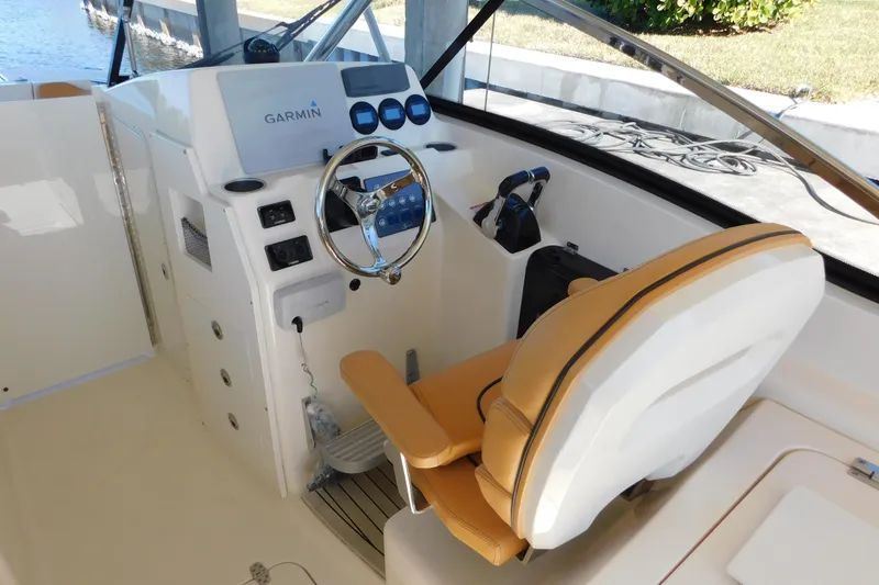Slide: The Image of 2015 Scout 275 Dorado boat helm with Garmin navigation system and tan seating. - 11