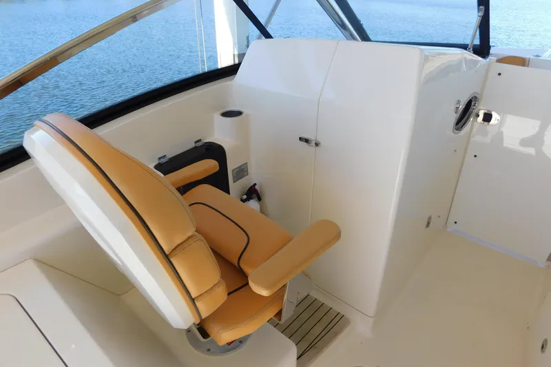 Slide: The Image of 2015 Scout 275 Dorado boat interior with tan seating and helm station. - 12