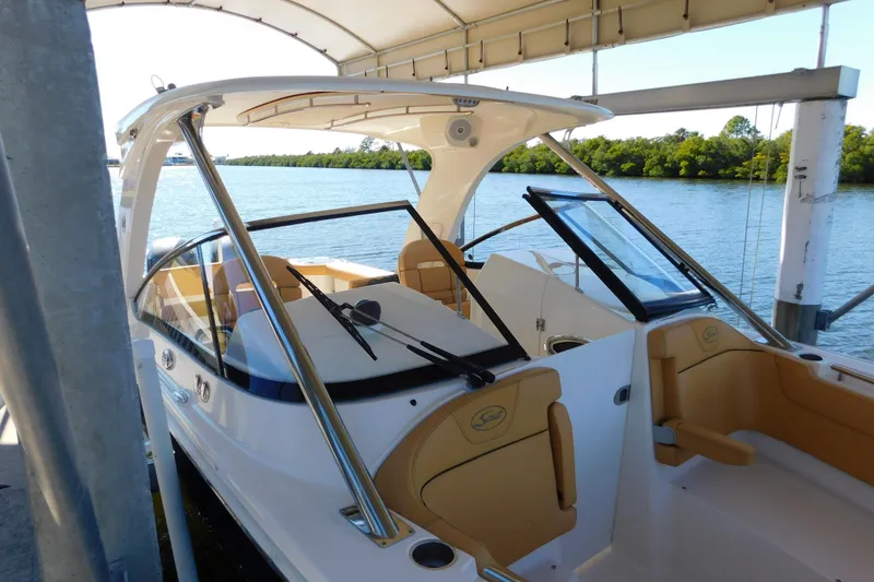 Slide: The Image of 2015 Scout 275 Dorado boat docked under a canopy, with scenic water view. - 35