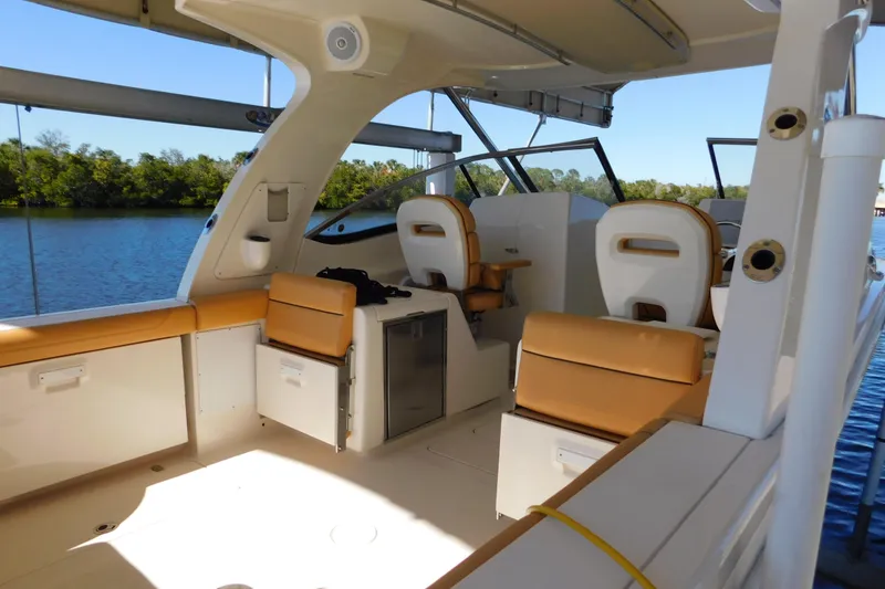 Slide: The Image of 2015 Scout 275 Dorado boat interior with tan seating and water view. - 5