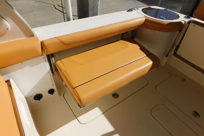 Slide: The Image of 2015 Scout 275 Dorado boat interior with tan leather seating and cup holder. - 6