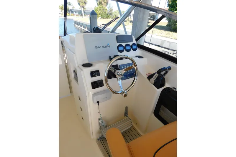Slide: The Image of 2015 Scout 275 Dorado boat helm with Garmin navigation system and steering wheel. - 9