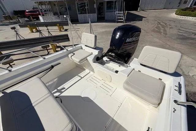 Slide: The Image of 2018 Boston Whaler 170 Montauk boat interior with Mercury engine, docked outdoors. - 14