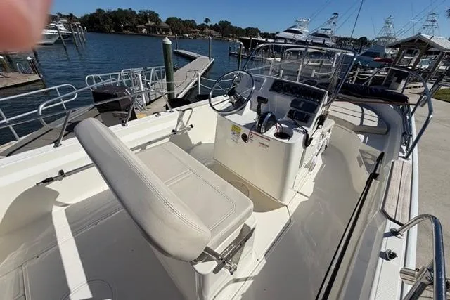 Slide: The Image of 2018 Boston Whaler 170 Montauk boat interior at marina, featuring steering console and seating. - 17
