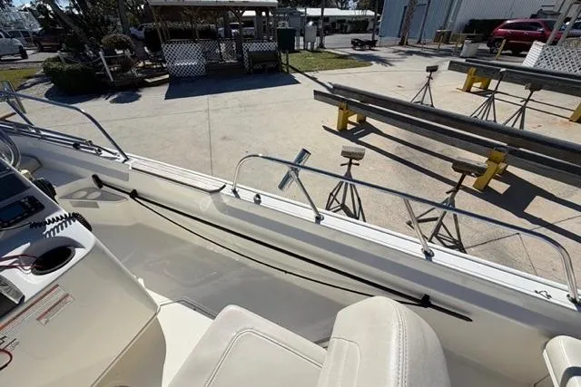 Slide: The Image of 2018 Boston Whaler 170 Montauk interior with seating and railing, docked at a marina. - 23