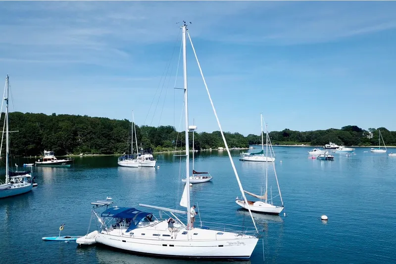 Slide: The Image of Sailboats anchored in a serene harbor, featuring a 2003 Beneteau 423. - 18