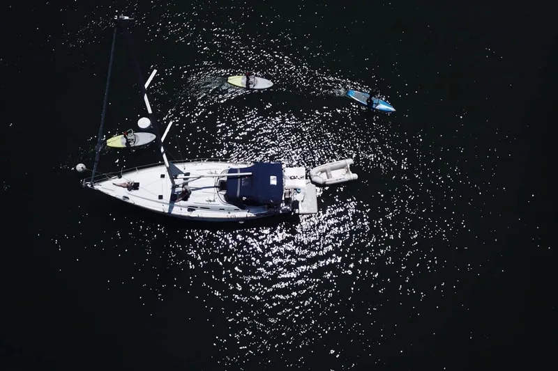 Slide: The Image of Aerial view of 2003 Beneteau 423 sailboat with paddleboarders on sparkling water. - 24