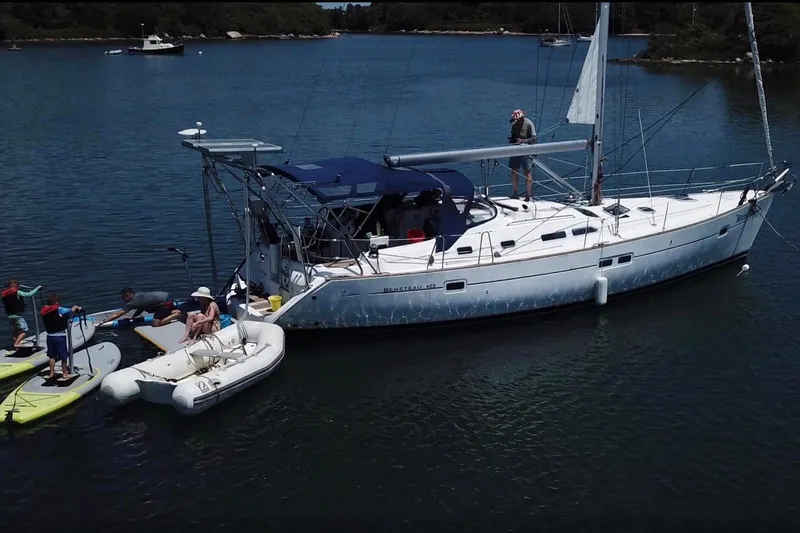 Slide: The Image of 2003 Beneteau 423 sailboat anchored with people paddleboarding nearby. - 27