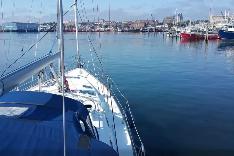 Slide: The Image of Sailboat Beneteau 423 (2003) docked in a calm marina with cityscape background. - 29