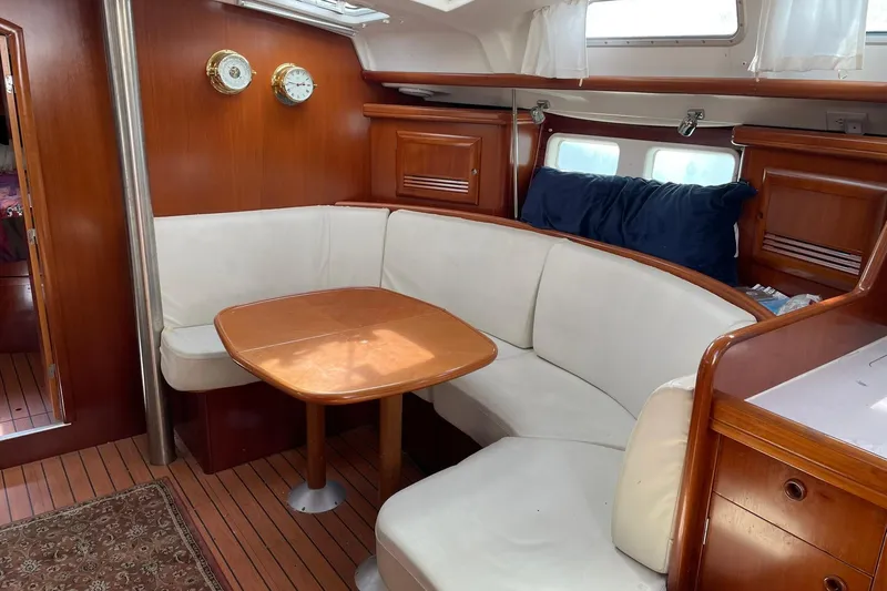 Slide: The Image of Interior of 2003 Beneteau 423 yacht with cozy dining area and wooden finishes. - 42