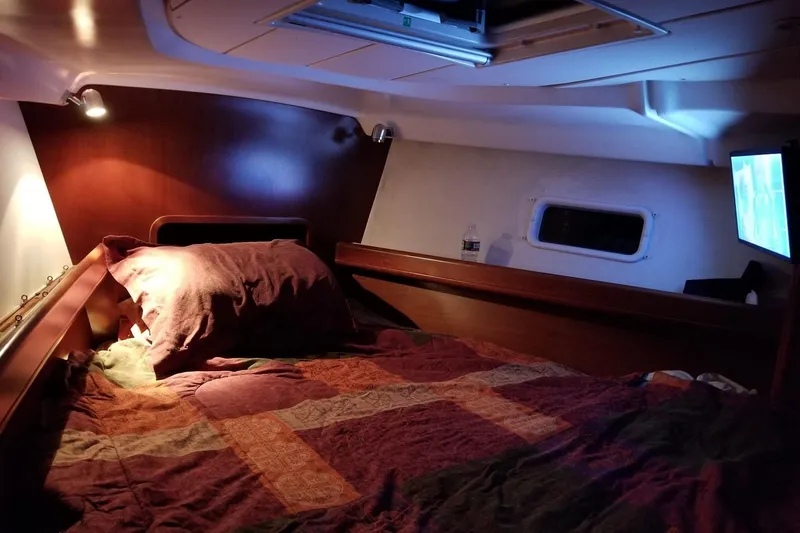 Slide: The Image of Cozy cabin interior of 2003 Beneteau Oceanis Clipper 423 sailboat with bed and porthole. - 7