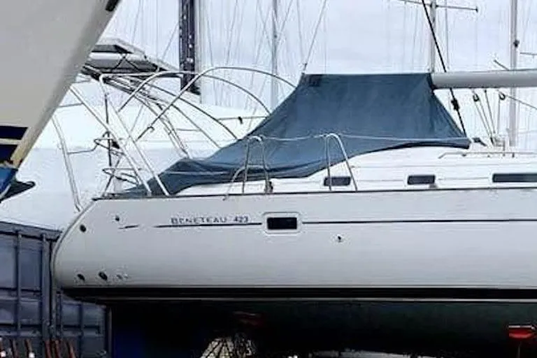 Slide: The Image of 2003 Beneteau Oceanis Clipper 423 sailboat docked, covered with a blue tarp. - 2