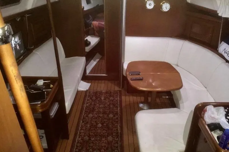 Slide: The Image of Interior of 2003 Beneteau Oceanis Clipper 423 yacht with cozy seating and wooden finishes. - 8