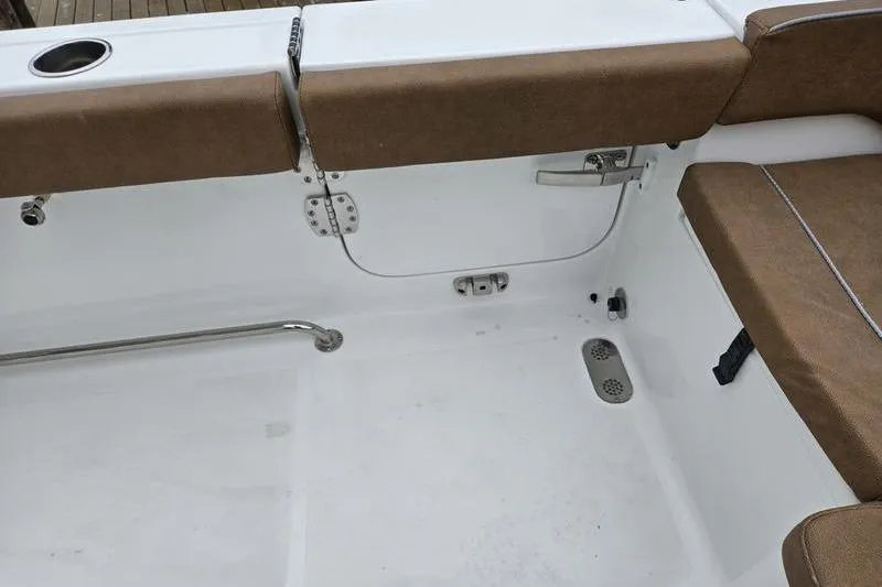 Slide: The Image of 2026 Sea Hunt Ultra 275 SE boat interior with brown seating and stainless steel fixtures. - 10