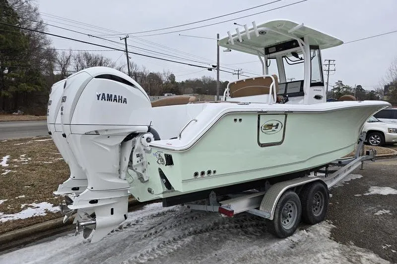 Slide: The Image of 2026 Sea Hunt Ultra 275 SE boat on trailer with Yamaha engines, parked outdoors. - 14