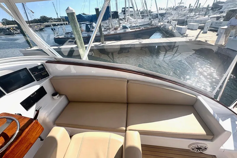Slide: The Image of 1991 Garlington 44 Express yacht interior with beige seating, docked at marina. - 11