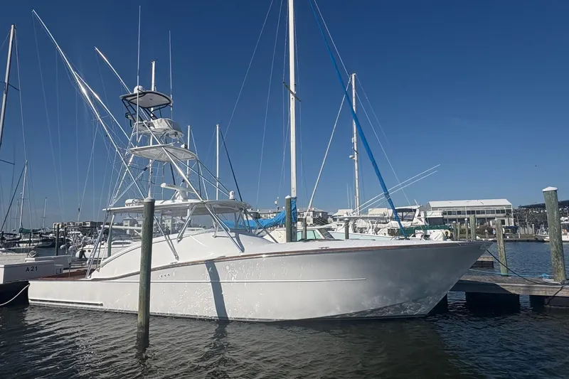 Slide: The Image of 1991 Garlington 44 Express yacht docked at marina under clear blue sky. - 2