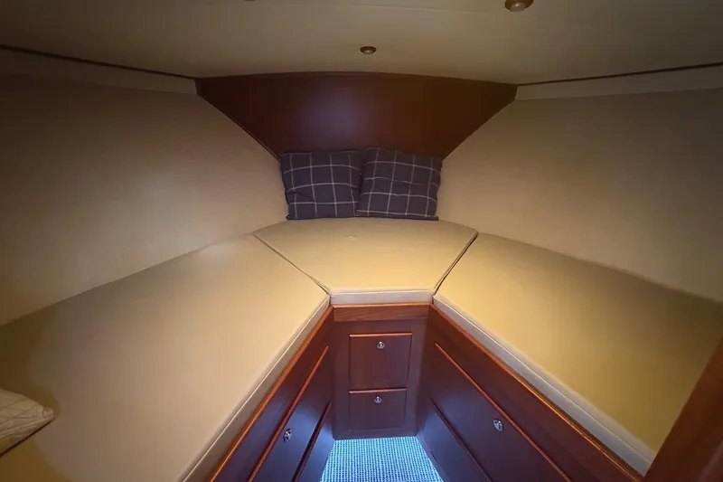 Slide: The Image of Cozy cabin interior of 1991 Garlington 44 Express with cushioned bed and wooden storage. - 23